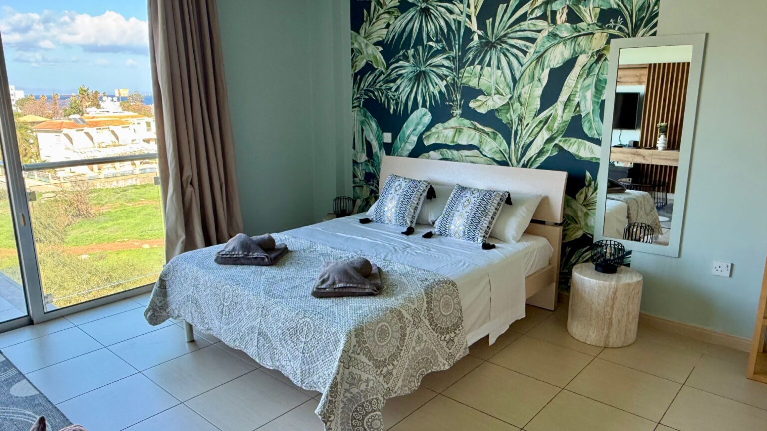 Coralli A309 studio in Protaras after furnishing by Too Coool, bed with feature wallpaper